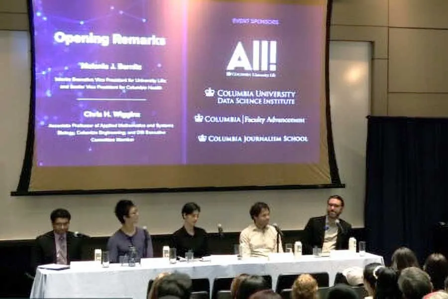 five people at tables on stage