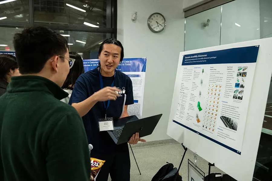 photo of man presenting a poster and another man listening