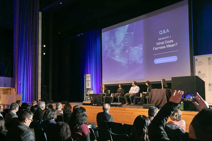 audience at a conference in front of a big screen