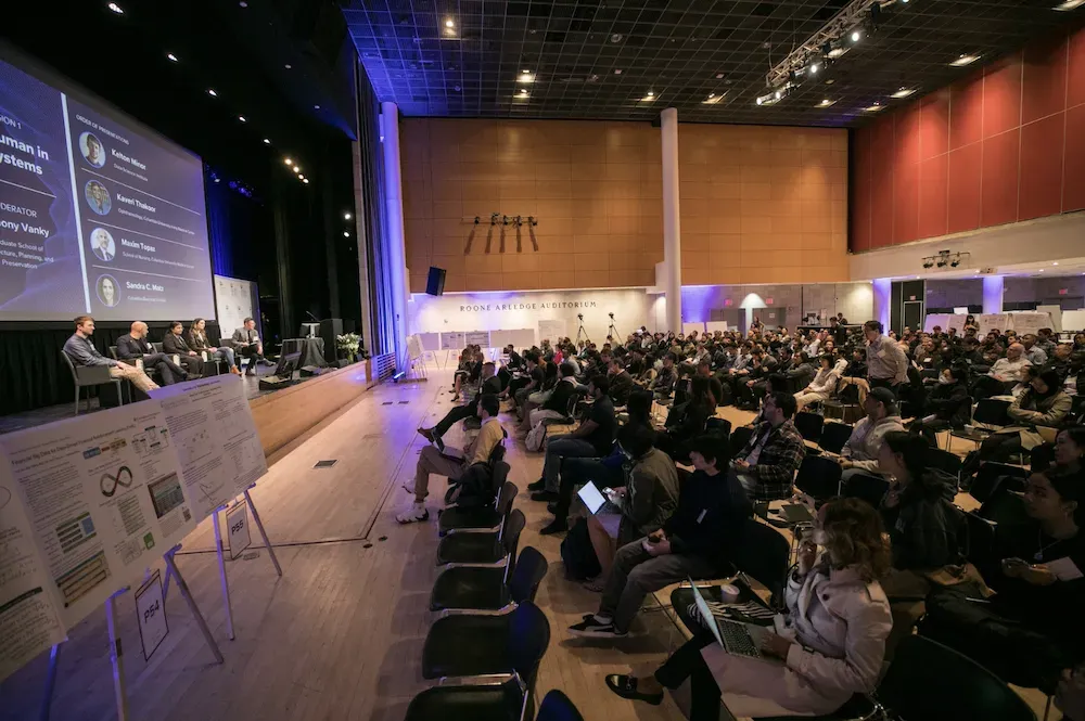 audience listening to a panel discussion at DAX 2023