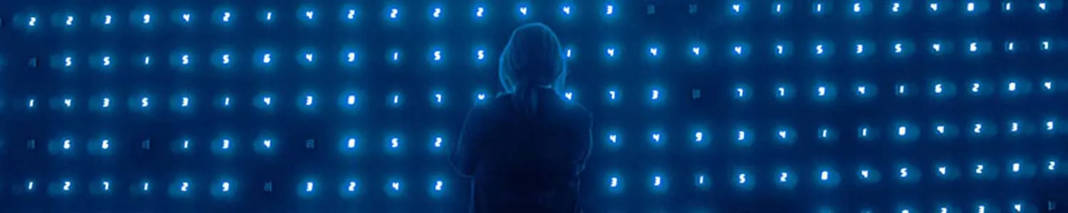 woman facing a large screen of data