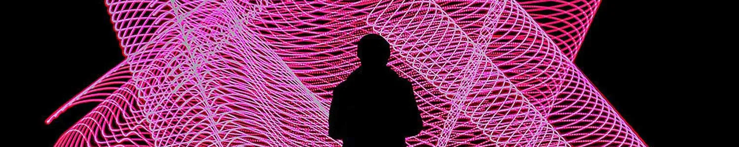 person facing a large screen with pink abstract images on it